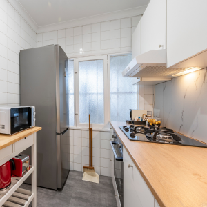 Vista de la cocina con frigorífico, fogones de gas y utensilios en alojamiento turístico cerca de la playa